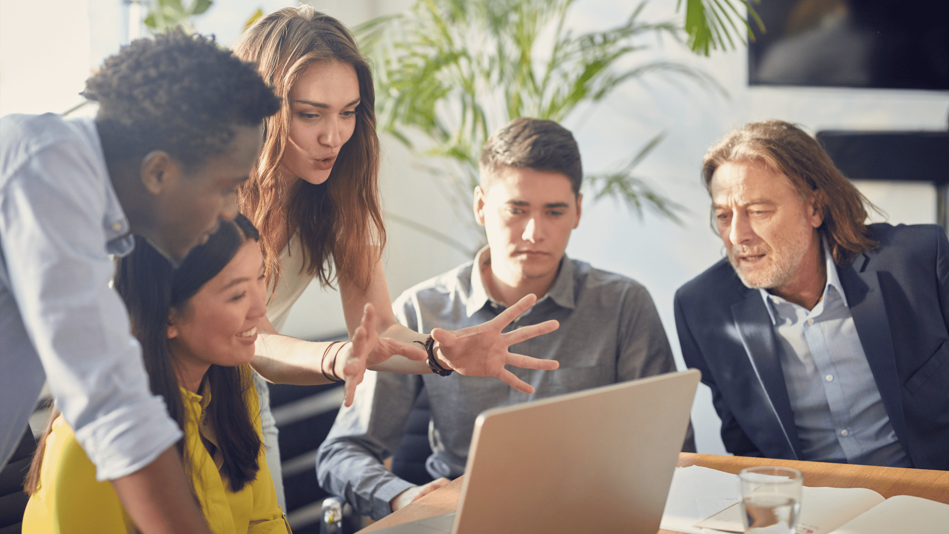 A group of business professionals discussing our business startup services using a laptop.