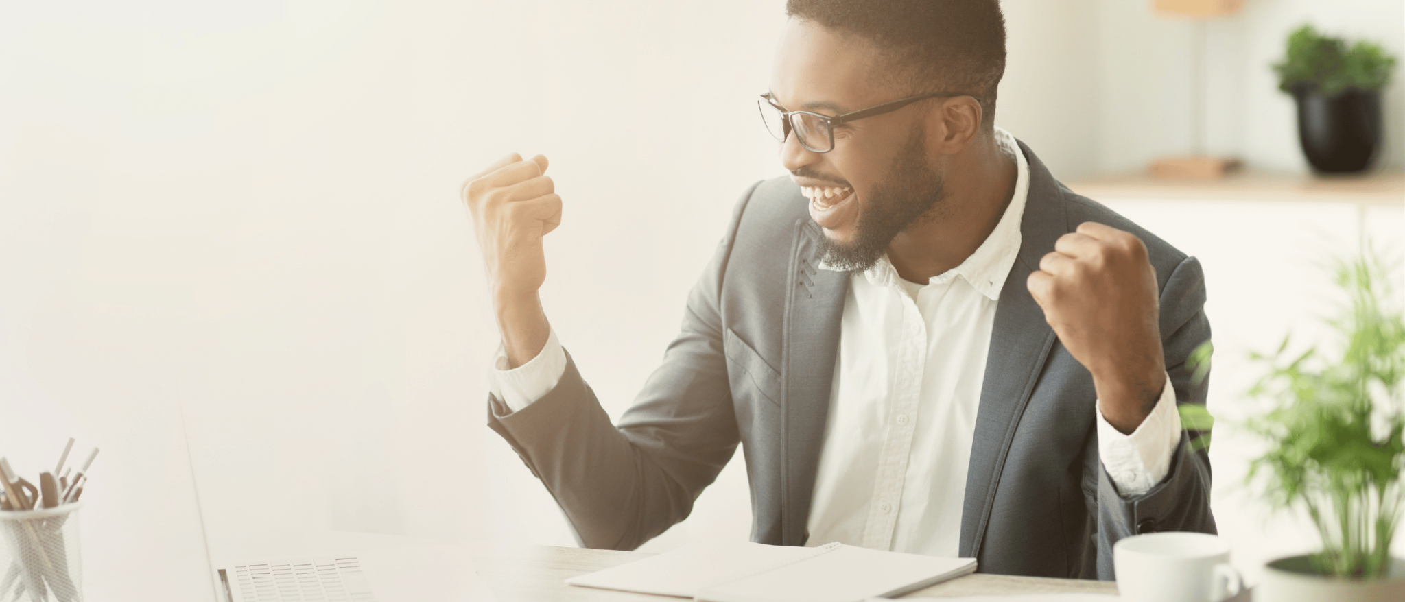 A man is excited that his completed contact us form on his laptop is sent to the We're Here To Assist You team.